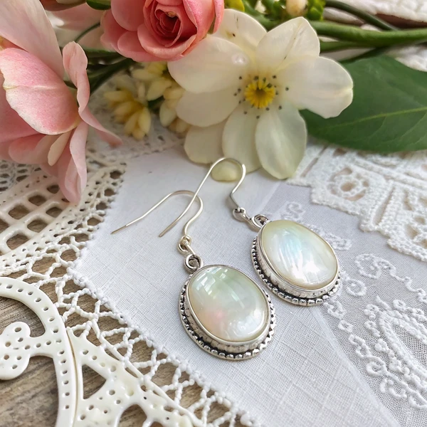 Mother of pearl earrings set in sterling silver showing natural iridescent shimmer