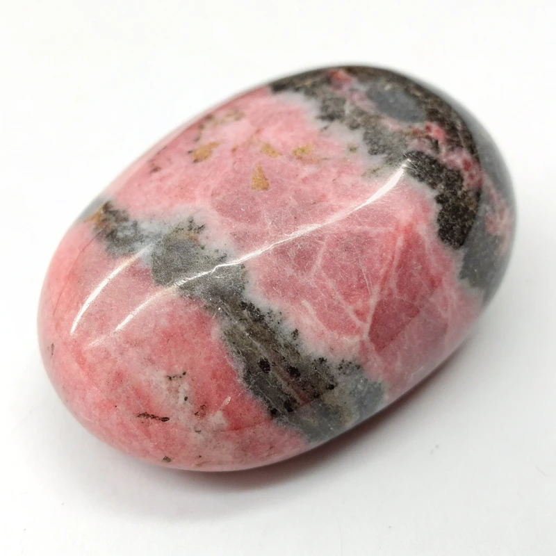 Nephrite Jade Stones Closeup Natural rhodonite gemstone displaying pink base color with characteristic black manganese oxide patterns